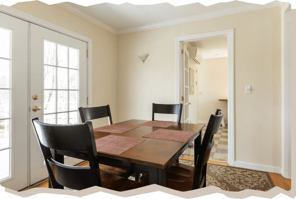 Dining area with a wooden table and black chairs in Windy Knob Cottage Airbnb.