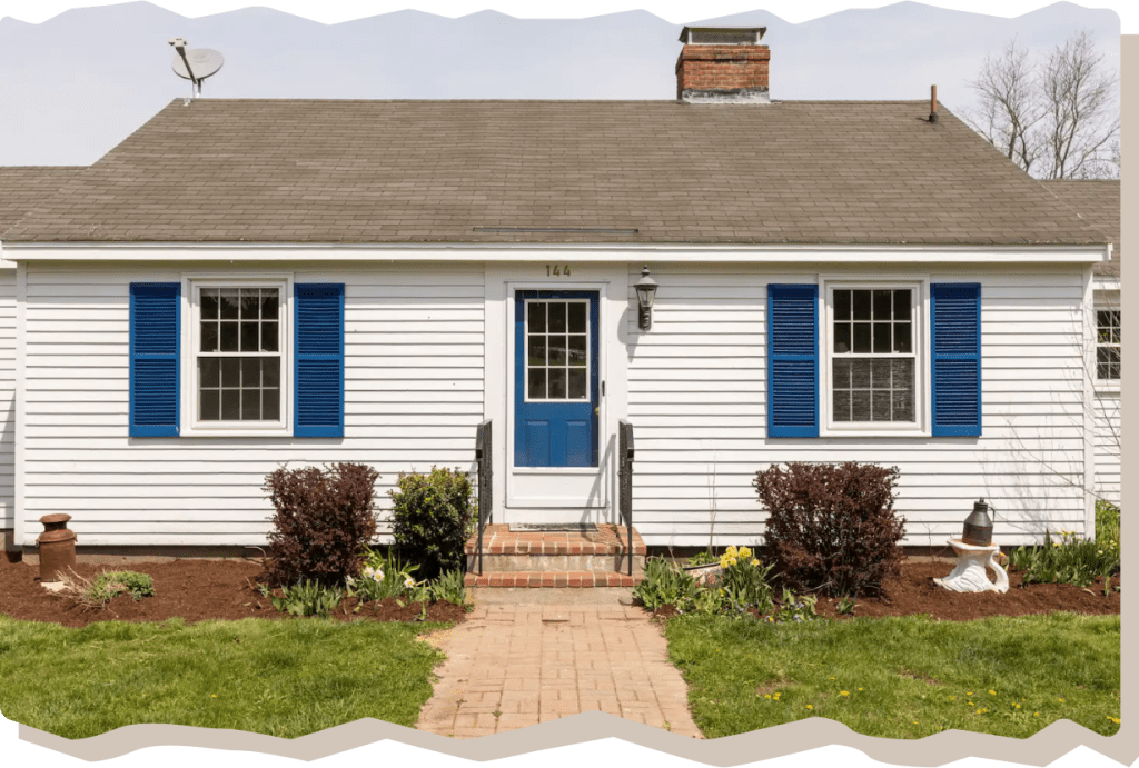 Front view of the Windy Knob Cottage Airbnb with blue shutters and a blue door.
